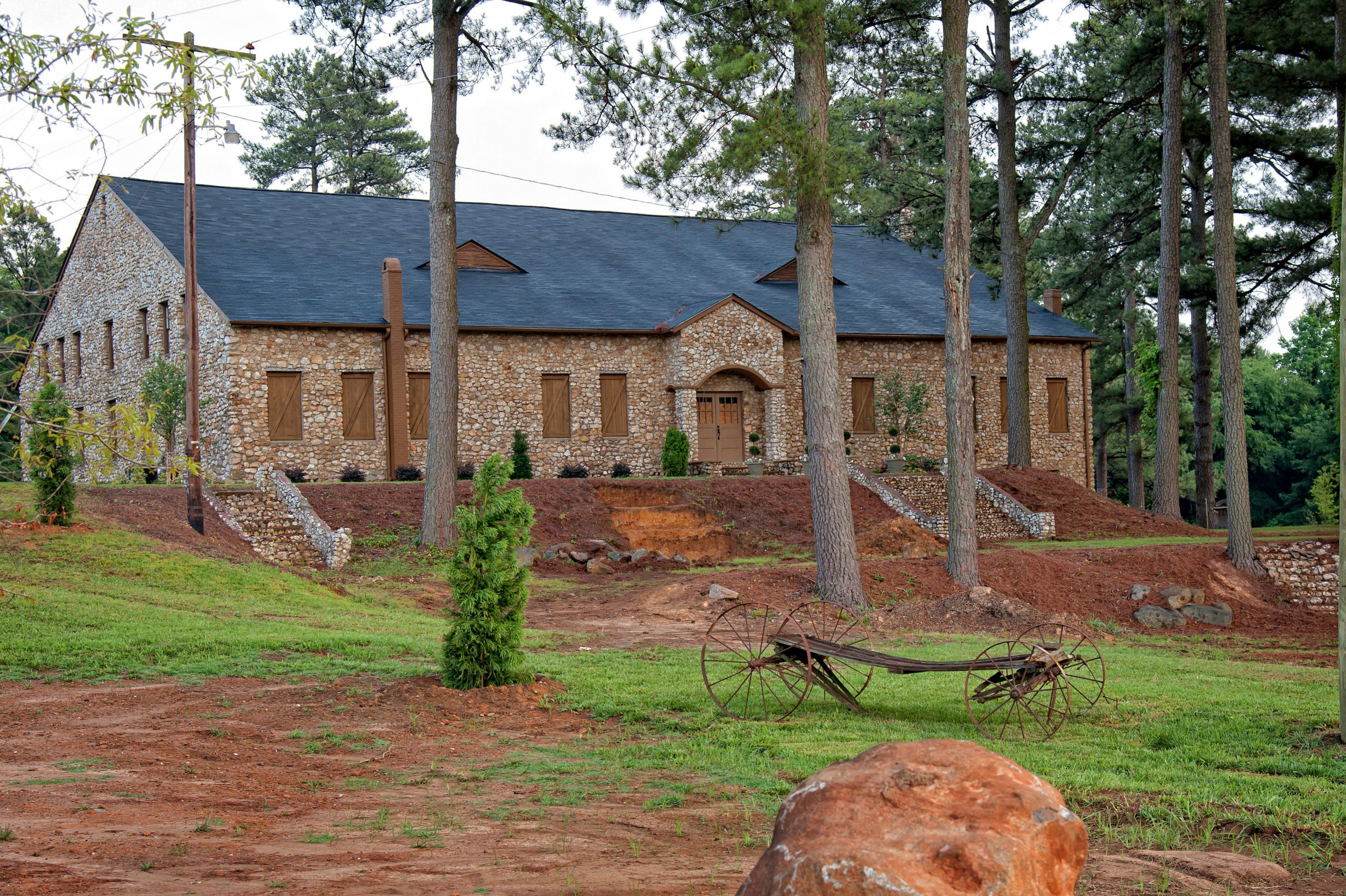 A long church serving as a venue for a wedding reception, with tall trees nearby adding to the scenic ambiance of the setting